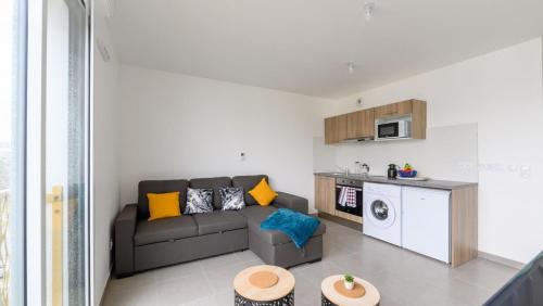 - un salon avec un canapé et un four micro-ondes dans l'établissement Le MontCalm à Villepinte, à Villepinte