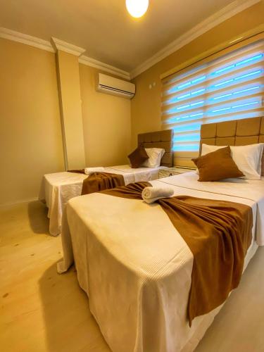 three beds in a room with a window at Villa 77 in Kaş