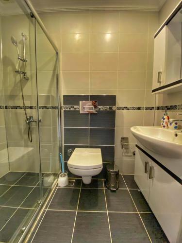 a bathroom with a shower and a toilet and a sink at Villa 77 in Kaş