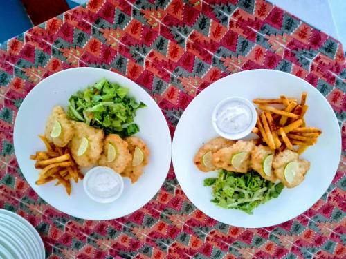 two plates of food with shrimp and fries on a table at Best Hostel in Kathmandu