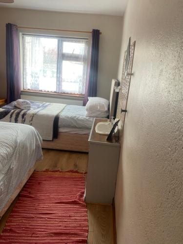 a small bedroom with two beds and a window at Bluebell apartment sleeps 7 only let as whole apartment in Blennerville