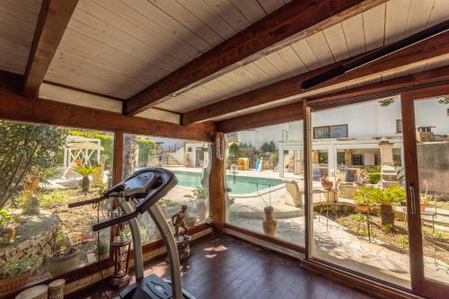 a gym with a view of a swimming pool at Villa La Gioconda in Neviano