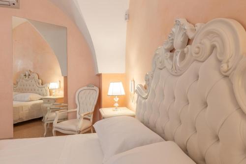 a white bedroom with a bed and a room with a bedsenalsenal at Villa La Gioconda in Neviano