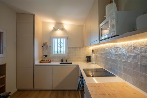 a kitchen with white cabinets and a window at Picasso Mountain View Begur in Begur