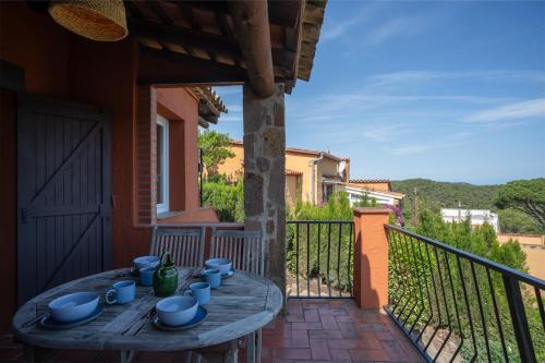 a wooden table on a balcony with blue dishes on it at Picasso Mountain View Begur in Begur