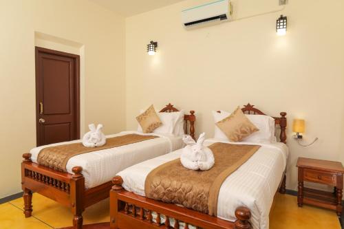 Ένα ή περισσότερα κρεβάτια σε δωμάτιο στο Franco Tamil Villas by Western Valley Resorts