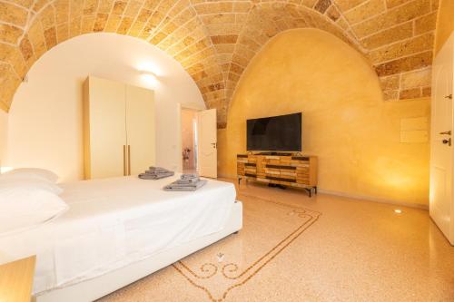 a bedroom with a bed and a flat screen tv at Villa La Gioconda in Neviano