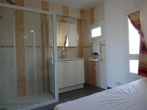 une salle de bain avec une douche en verre et un lavabo dans l'établissement CapNat - Village Naturiste - Port Nature - Le Chili Pepper, au Cap d'Agde