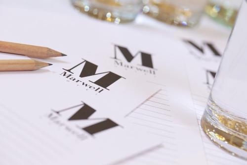 a table with a glass of wine and a napkin with the word menu at Marwell Hotel Winchester South in Winchester