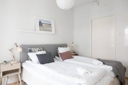 a bedroom with two beds with white sheets at Fredika, modern 1br,Tripla Pasila prime location, gym, parking, train station near in Helsinki