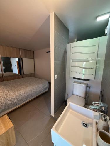 a small bathroom with a bed and a sink at Dépendance au sein d’une villa avec piscine in Aix-en-Provence