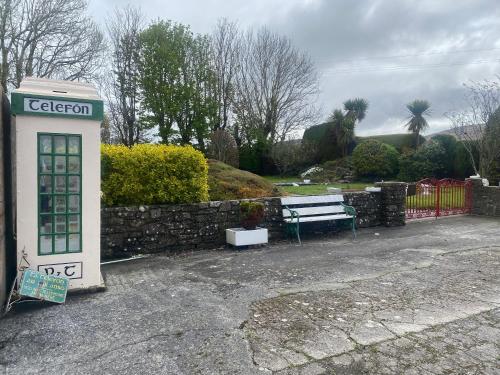 an old phone booth sitting next to a bench at Bluebell apartment sleeps 7 only let as whole apartment in Blennerville