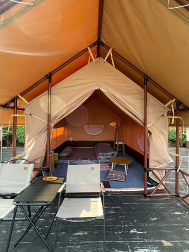 a tent with two chairs and a table at Khu Nghỉ Dưỡng Tâm An 999 & Coffee in Mộc Châu