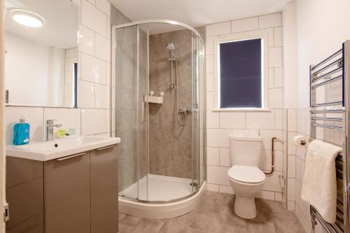 a bathroom with a shower and a toilet and a sink at Dunedin Guest House in Penzance