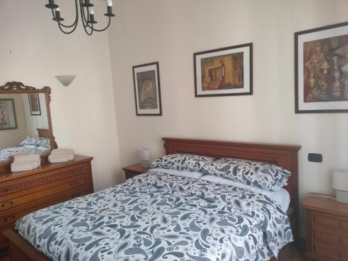 a bedroom with a bed and some pictures on the wall at La casa di Norma- Anzio Centro 4 posti letto in Anzio