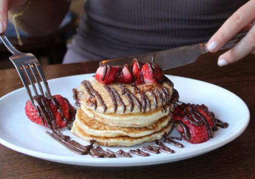 a plate with a stack of pancakes with strawberries at Black Lion Hotel Manchester in Manchester