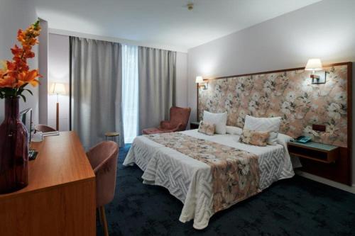 a hotel room with a bed and a desk at Ramblas Vendrell in El Vendrell