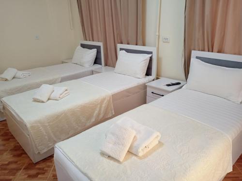 a hotel room with two beds with towels on them at Hotel Murodjon in Samarkand