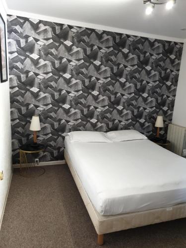 - une chambre avec un lit et un mur recouvert de triangles dans l'établissement Appartement T3 Centre Bordeaux avec parking, à Bordeaux