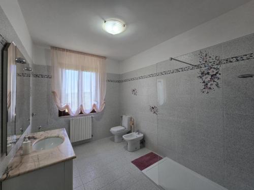a bathroom with a sink and a toilet and a tub at Manciano Holiday Apartments in Manciano