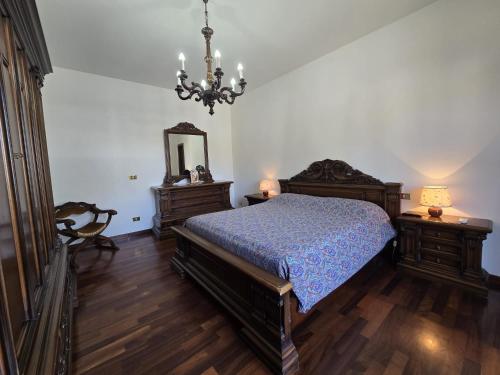a bedroom with a bed and a mirror and a chandelier at Manciano Holiday Apartments in Manciano