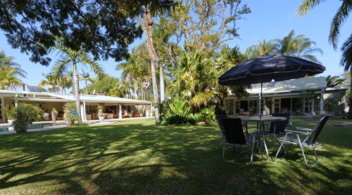 a table and chairs under an umbrella in a yard at Ridgeway Place in Harare