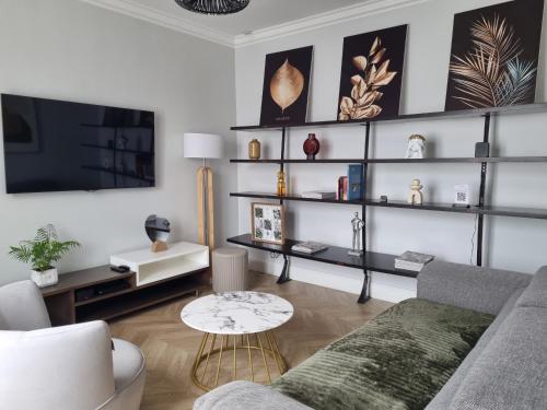 un salon avec un canapé et une télévision dans l'établissement Appartement à proximité de Paris, à Vitry-sur-Seine