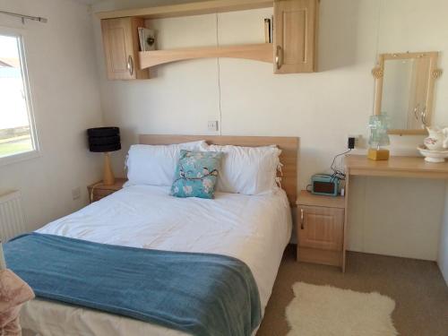 a bedroom with a bed with a pillow on it at Private caravan situated at Parkdean Holiday Resort St Margaret's at Cliffe number 18 in St Margarets at Cliff