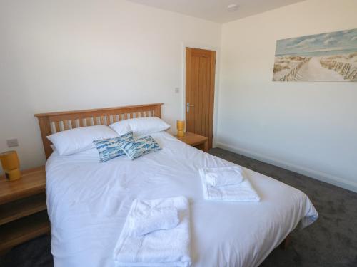 a bedroom with a white bed with towels on it at Arfryn in Haverfordwest