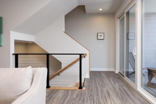 a living room with a staircase and a couch at Lake Life At The Cove - Gateway To Summer Fun! in Lake George