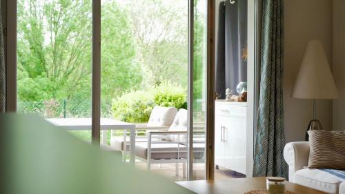 a living room with a sliding glass door to a patio at Joli T2 avec jardin proche du château d'Arcangues in Arcangues