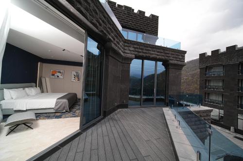 a bedroom with a bed and a balcony at Mounthree in Pʼambak