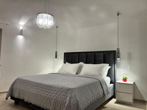a white bedroom with a bed with a black headboard at Amore in Gornji Humac