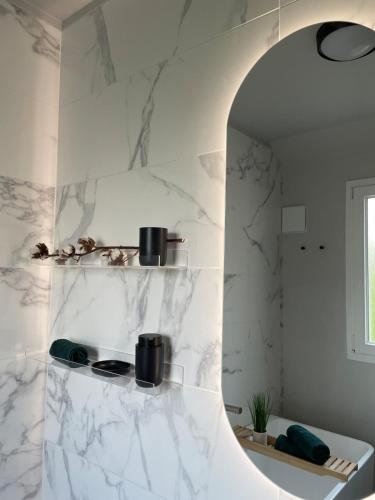 une cuisine avec des murs en marbre blanc et un miroir dans l'établissement Comfort & Design Apartment in Orléans, à Orléans