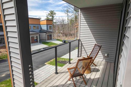 a balcony with two chairs and a view of a street at Mountain Vista- Brand New, Close To The Lake in Lake George