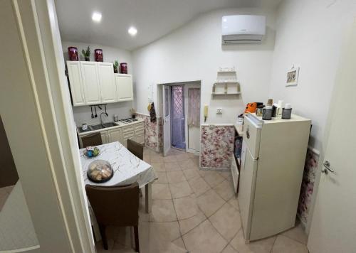 una piccola cucina con frigorifero e tavolo di Casa vacanza Vinci house Ercolano a Ercolano