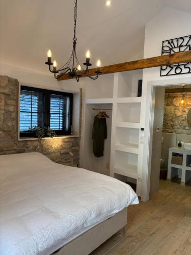 a bedroom with a white bed and a chandelier at Vila Espinosa in Trebinje