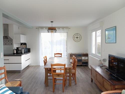 une cuisine et une salle à manger avec une table et des chaises dans l'établissement maison TY MAD, à Saint-Quay-Portrieux