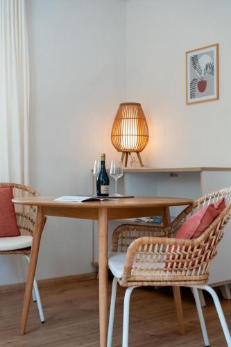 a dining room table with a lamp and two chairs at Dorfapartment Achensee in Maurach