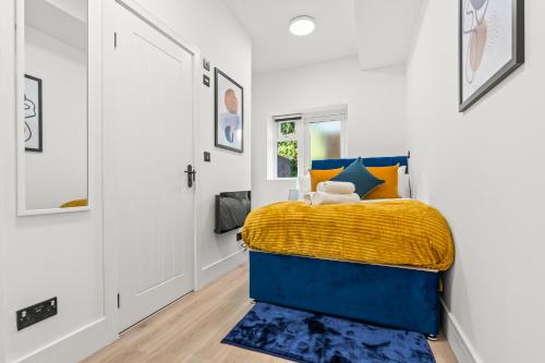 a bedroom with a blue bed with a yellow blanket at Stunning 4 Bed, Sleeps 10, Parking in London
