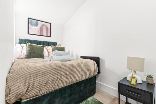 a bedroom with a bed with a green headboard at Stunning 4 Bed, Sleeps 10, Parking in London