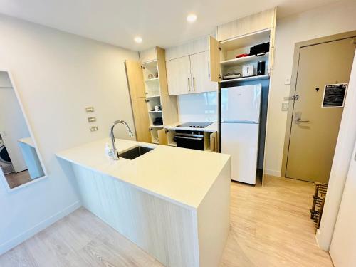 a kitchen with a white counter and a refrigerator at Sky Tower Panorama Suite Luxurious Apartment in Auckland