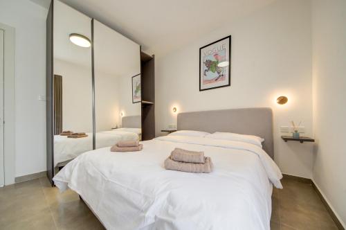 a bedroom with two beds and a large mirror at The Valley Collection - Suite B23 in Xagħra