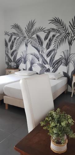 a bedroom with a white bed and a mural of palm trees at Leu Zarlor Location in Piton Saint-Leu