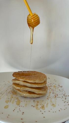 a stack of pancakes with a spoon of peanut sauce at Vias in Neapolis