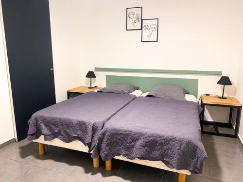 a bedroom with a large bed with two night stands at Leu Zarlor Location in Piton Saint-Leu