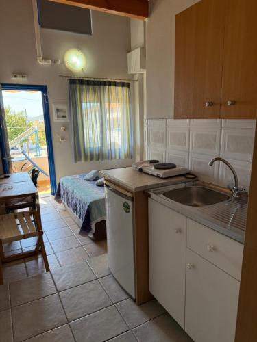 a kitchen with a sink and a room with a bed at Vias in Neapolis