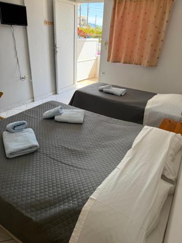 two beds in a room with towels on them at Vias in Neapolis