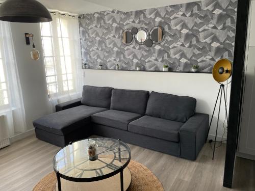 un salon avec un canapé et une table en verre dans l'établissement La Terrasse Victor Hugo - Hypercentre, Idéal Groupe, à Saint-Omer