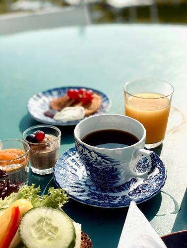 a table with a cup of coffee and a plate of food at Bongska Huset in Abbekås